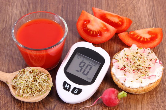 Glucometer, freshly sandwich with vegetables, tomato juice, healthy nutrition