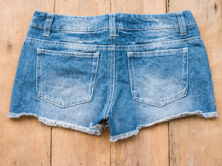 Short jean with belt on wood background
