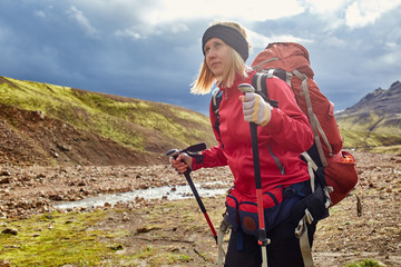 woman hiker with backpack on the trail in the trek in Iceland