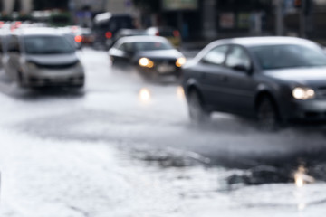 Fototapeta na wymiar car traffic on wet road after downpour. blurred view through car window.