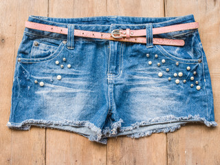 Short jean with belt on wood background
