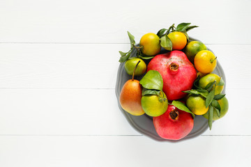Set of ripe seasonal autumn fruit on a white wooden background
