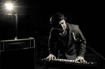 Fototapeta na wymiar Musician playing keyboard with music instrument on dark backgrou