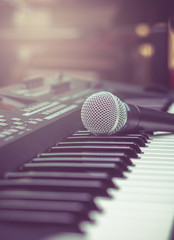 microphone on music keyboard with music brand blurred background