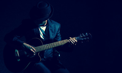 Musician playing the guitar on black background,music concept