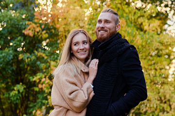 Fototapeta premium Bearded male hugs the cute blonde female on the date.