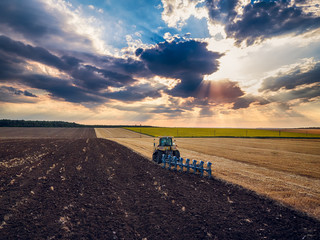 Tractor cultivating field at autumn