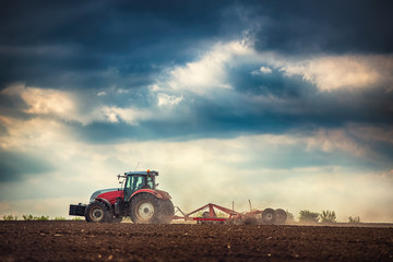 Farmer in tractor preparing land with seedbed cultivator