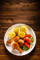 Grilled chicken legs with boiled potatoes and vegetable salad