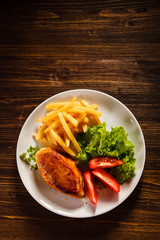 Fried chicken fillet, chips and vegetable salad