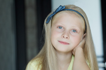 Head and shoulders indoor portrait of teenage girl with blue eyes and fair hair