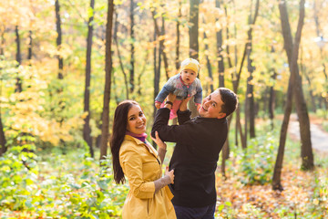 Happy family mother, father and baby in autumn nature