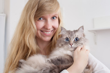 young woman holding ragdoll cat