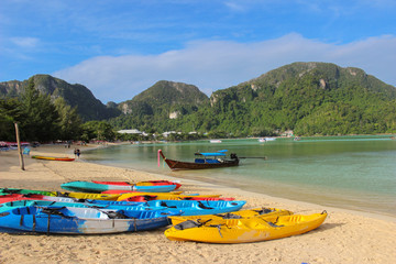 row of Kayaks canoes boats on the PhiPhi Don beach in Thailand
