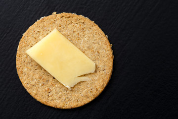 Single Scottish oatcake with a slice of yellow cheese.