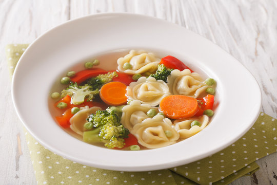 Italian tortellini soup with broccoli, peas, carrot and pepper close-up. horizontal
