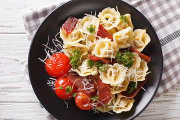 Freshly cooked tortellini with prosciutto and parmesan on a plate.  Horizontal top view
