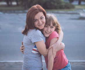 young pretty attractive caucasian mother having fun with teenage daughter hugs smiling cuddling