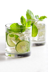 homemade mojito cocktail with fresh limes, mint, and ice