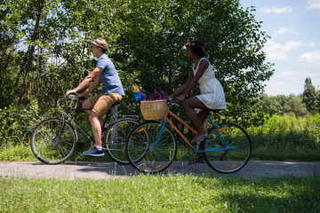 Obraz premium Young multiethnic couple having a bike ride in nature