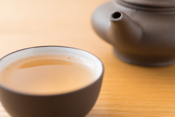 cup of tea and teapot on wood table close up