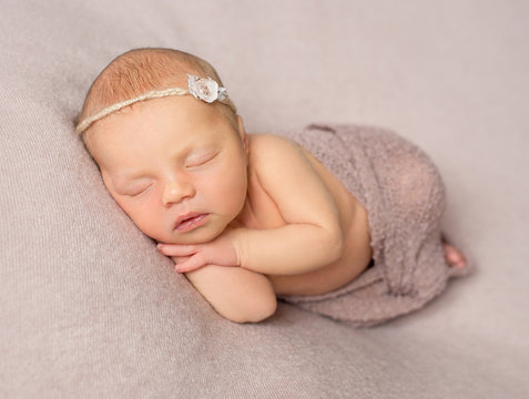 sweet sleeping newborn girl covered with shawl