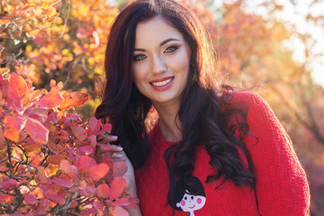 Beautiful smiling girl in colorful autumn leaves