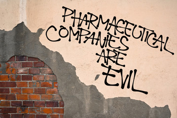 Pharmaceutical Companies Are Evil - handwritten graffiti sprayed on the wall - criticism of big...