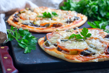 Home made fresh italian pizza with vegetable. Served on black stone surface.
