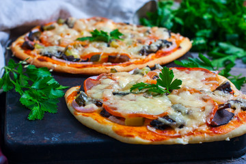 Home made fresh italian pizza with vegetable. Served on black stone surface.