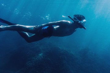 Male diver snorkeling underwater - obrazy, fototapety, plakaty