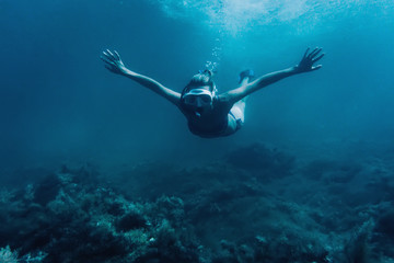 Woman snorkeling among seaweed