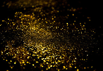 gold glitter lights on black background.