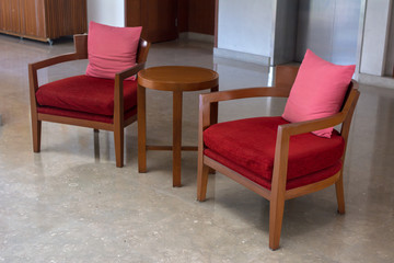 Red upholstered wooden chair in living room at reception modern hotel