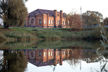 brick building near the water in autumn