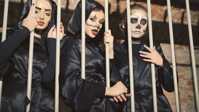 Three female vampires scaring and flirting in the lattices of catacomb in 4K