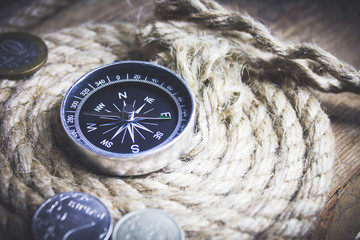 coin compass rope on a wooden table © Artvibe