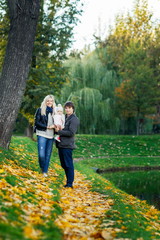 Obraz premium Portrait of family with little daughter in autumn park