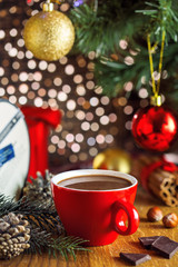 Cocoa drink in a cup near gift boxes under Christmas tree. Mug of traditional tasty winter beverage.