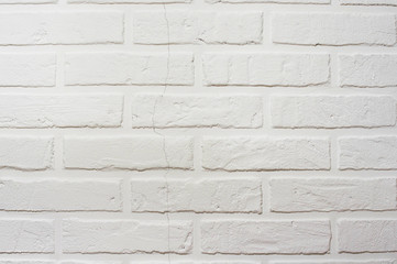 Decorative brick wall with a crack. White hand made wall background