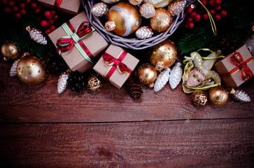 Christmas or New Year background: fur-tree, branches, gifts, colored glass balls, decoration and cones on wooden background