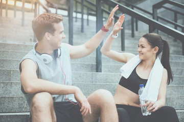 Active friends smiling and giving high five