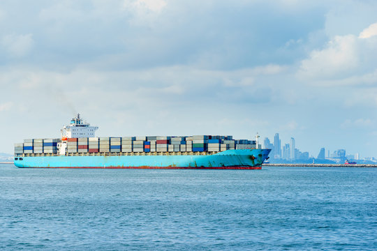 blue cargo container ship anchored in harbor