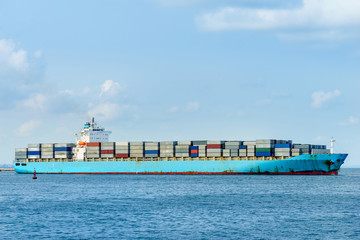 blue cargo container ship anchored in harbor