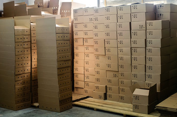 Cardboard boxes on wooden pallets in factory warehouse