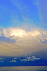Fototapeta na wymiar nubes en un cielo azul al atardecer con vistas al mar mediterraneo