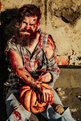 Zombie man with Halloween pumpkin