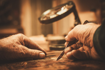Senior restorer working with antique decor element in his workshop