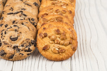 Biscuits with chocolate and peanut on old wooden table.