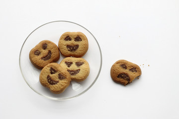 Halloween cookies in a plate and other of them isolated biten in a white background